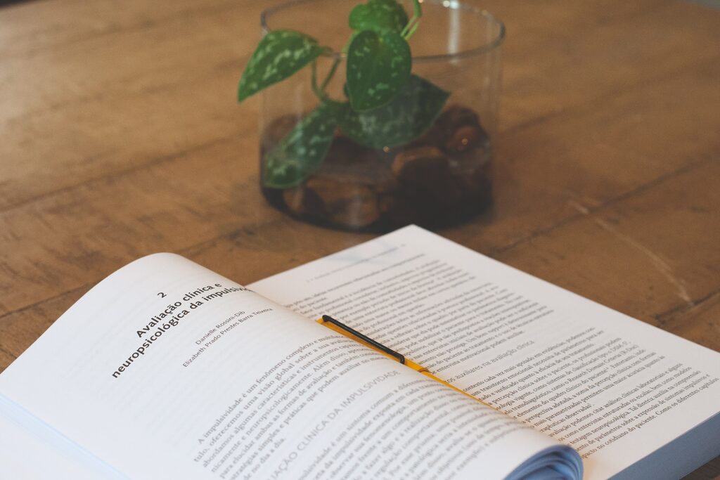 Livro aberto no capítulo “Avaliação clínica e neuropsicológica da impulsividade”, de Danielle Rossini-Dib.